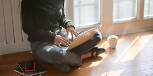 lady sitting on the floor with laptop on her lap